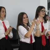 I ragazzi sono quasi tutti in tenuta di scena: una divisa scolastica costituita da camicia bianca, gonnellina o pantaloni neri e cravatta rossa...